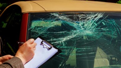 Insurance agent writing report on clipboard after car accident